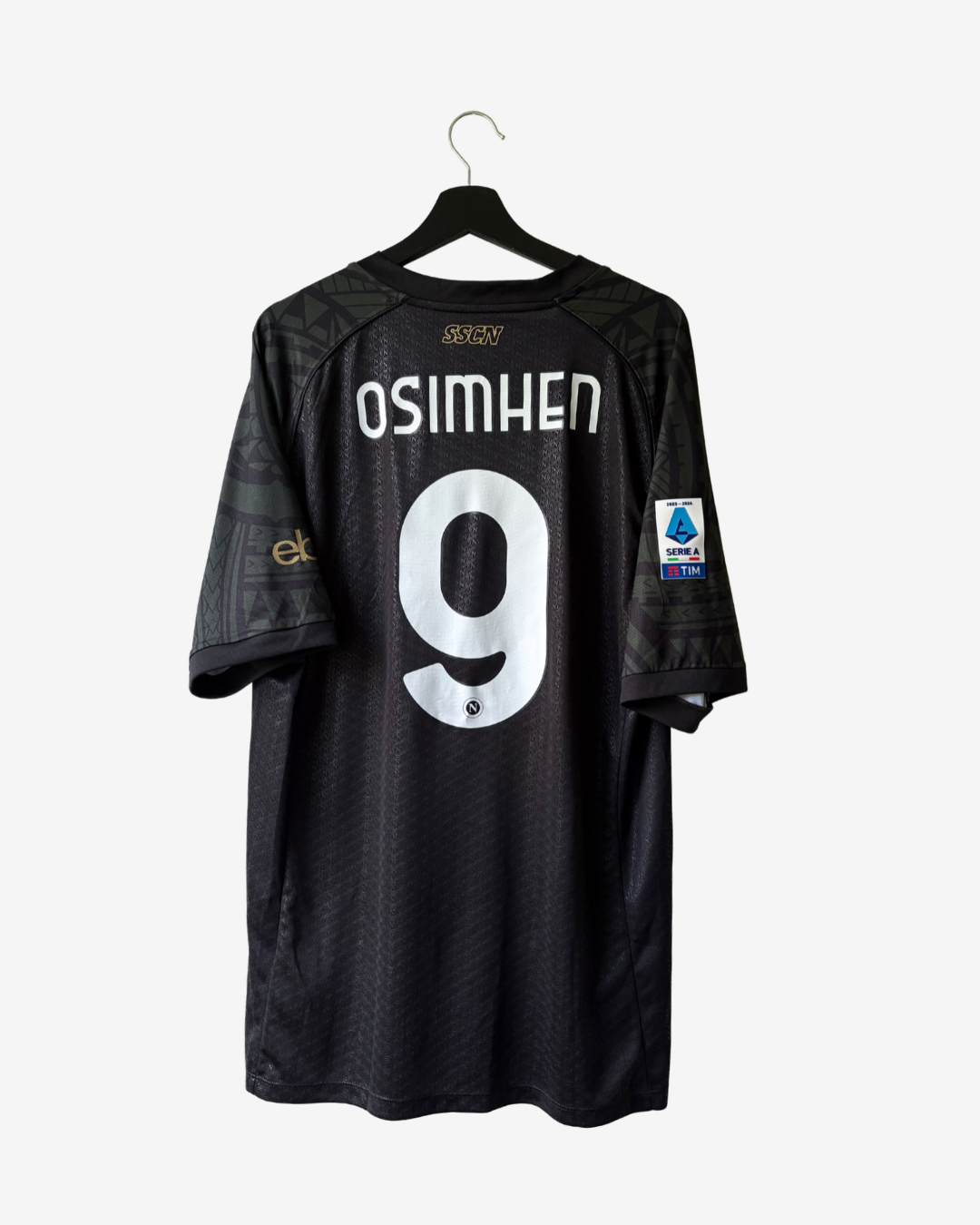 A black FC Groningen soccer jersey with 'OSIMHEN' and the number '9' printed in white on the back, hanging on a black hanger against a light gray background.