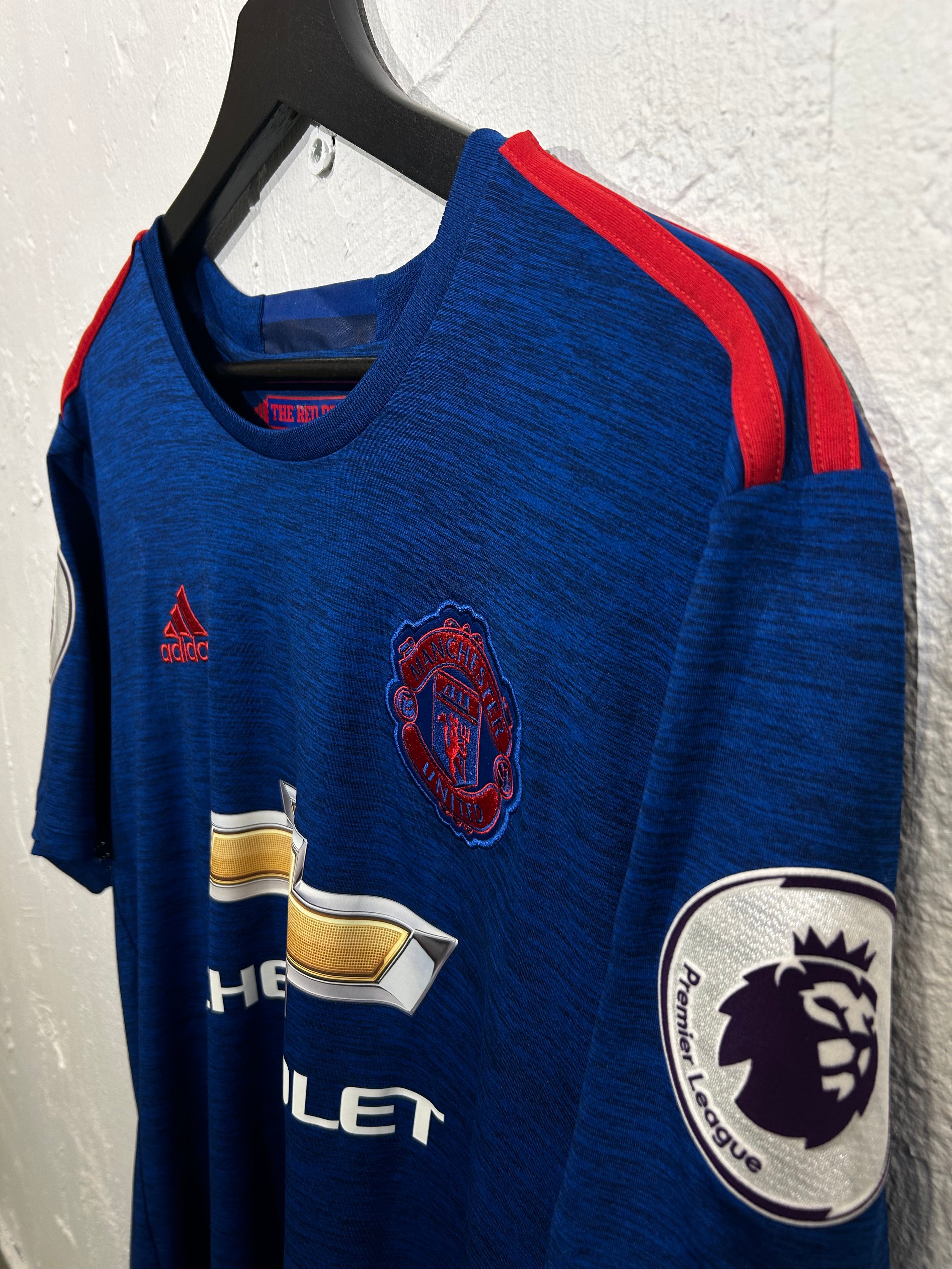 Blue sports jersey with red accents and visible branding on a white background