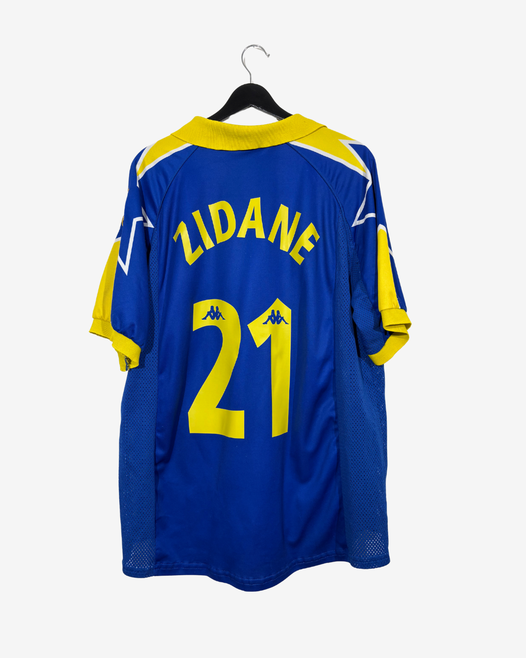 A blue and yellow Kappa soccer jersey with 'ZIDANE' and the number '21' printed on the back, hanging on a black hanger against a light gray background.