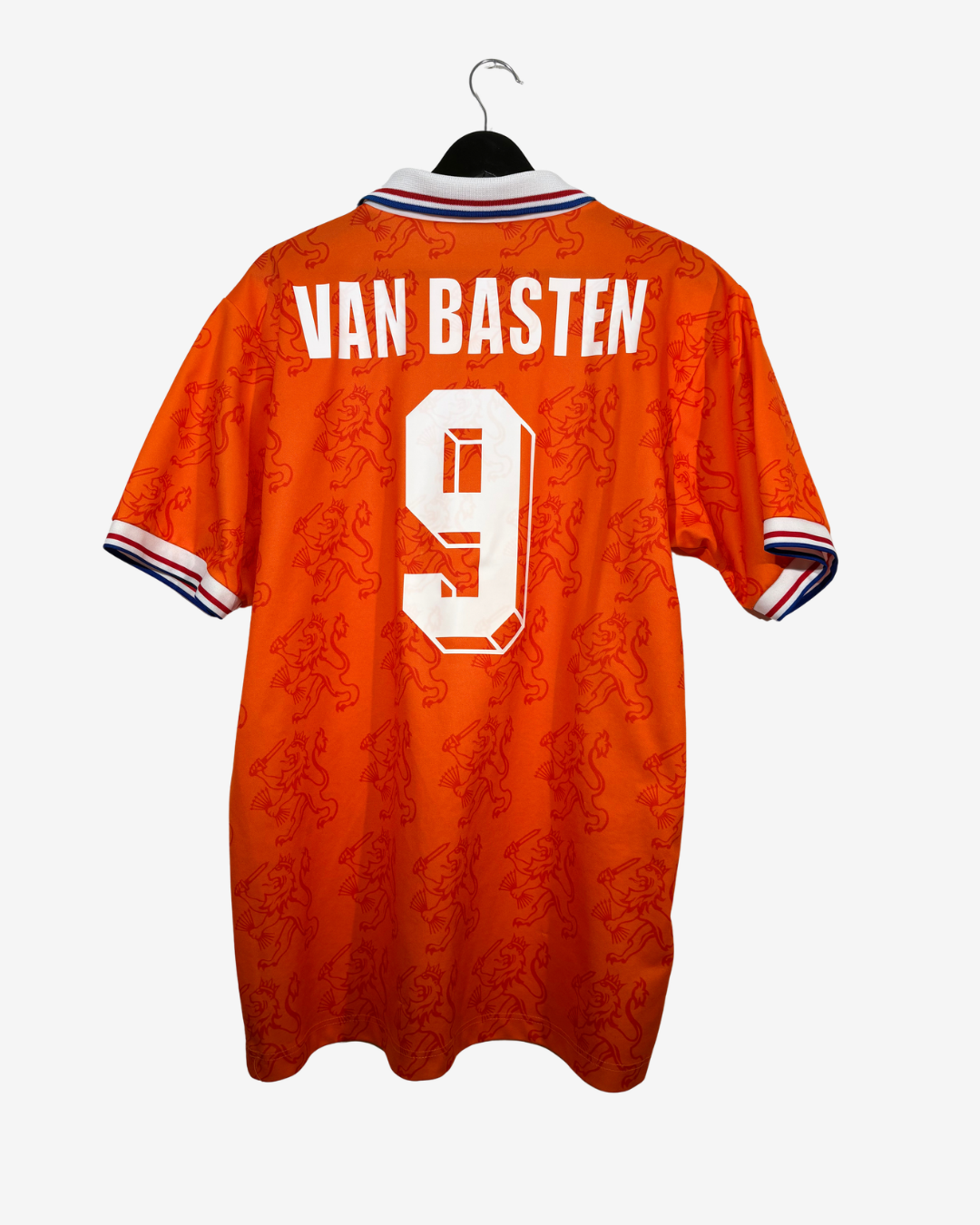 Orange Netherlands football jersey shown from the back on a black hanger, featuring 'VAN BASTEN' and the number '9' in white, with a subtle patterned design and striped collar and cuffs.