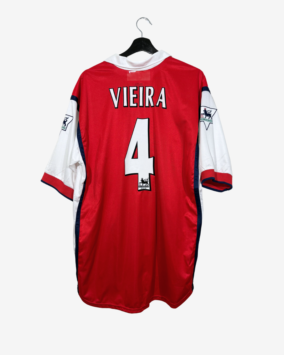 A red, white, and blue vintage soccer jersey hanging on a black hanger against a light gray background. The back of the jersey features the name 'VIEIRA' and the number '4' in white.