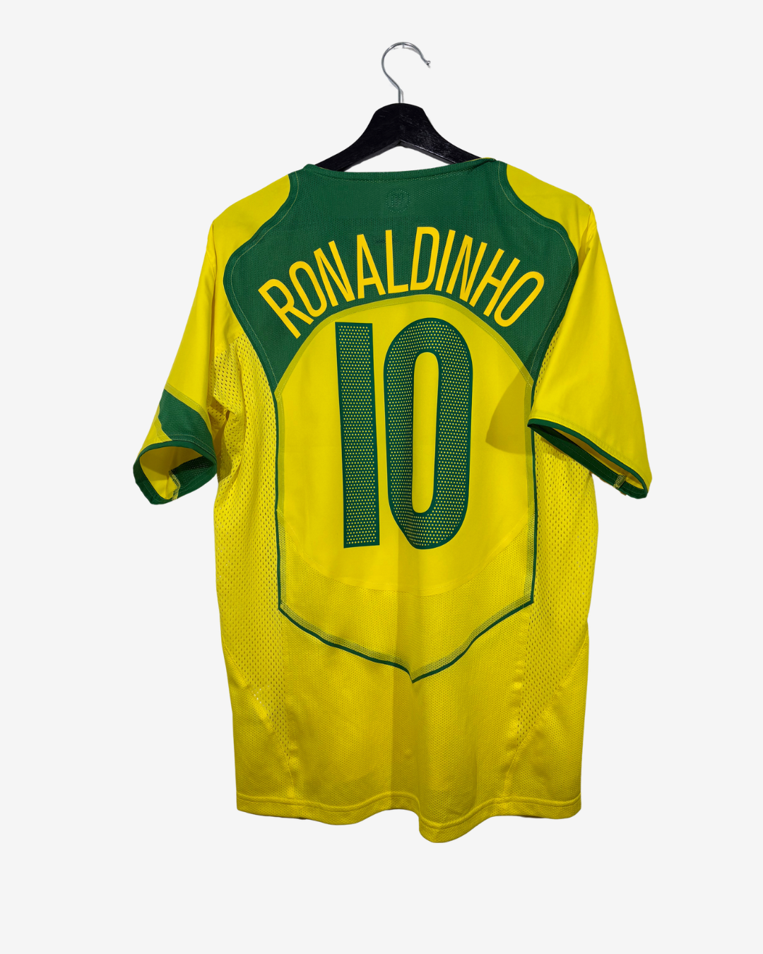 A yellow and green soccer jersey hanging on a black hanger against a light gray background. The back of the shirt features the name 'RONALDINHO' and the number '10' in green and yellow.
