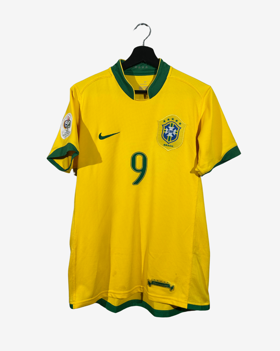 Yellow soccer jersey with green accents and number 9 on a hanger against a white background