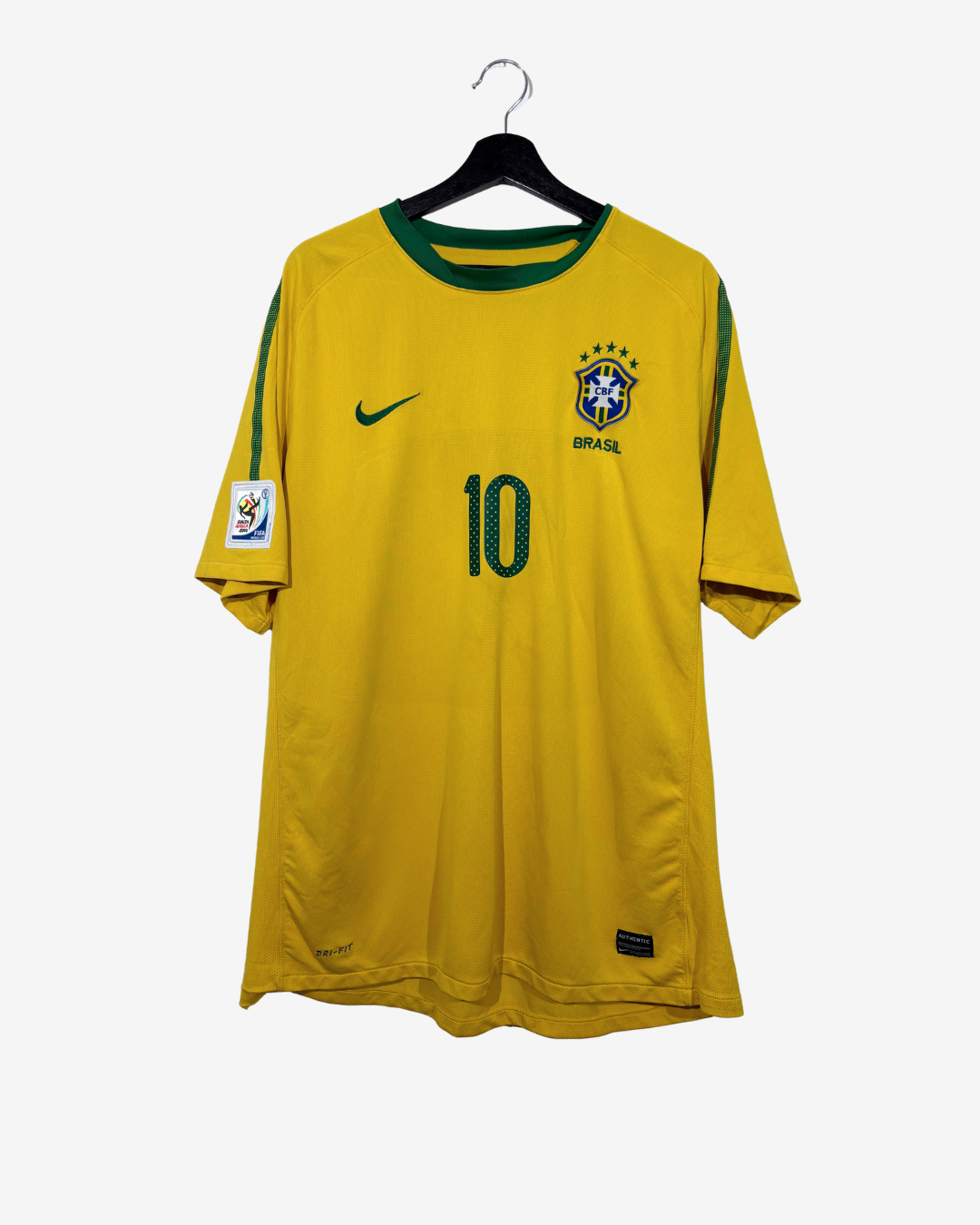 A yellow Brazil national football team jersey with green trim, featuring the number 10 on the front, a green Nike swoosh, and a CBF Brasil crest, hanging on a black hanger against a light gray background.