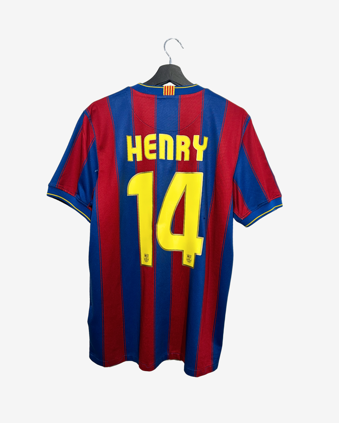 A vintage FC Barcelona home jersey with 'HENRY 14' printed on the back, hanging on a black hanger against a light gray background.