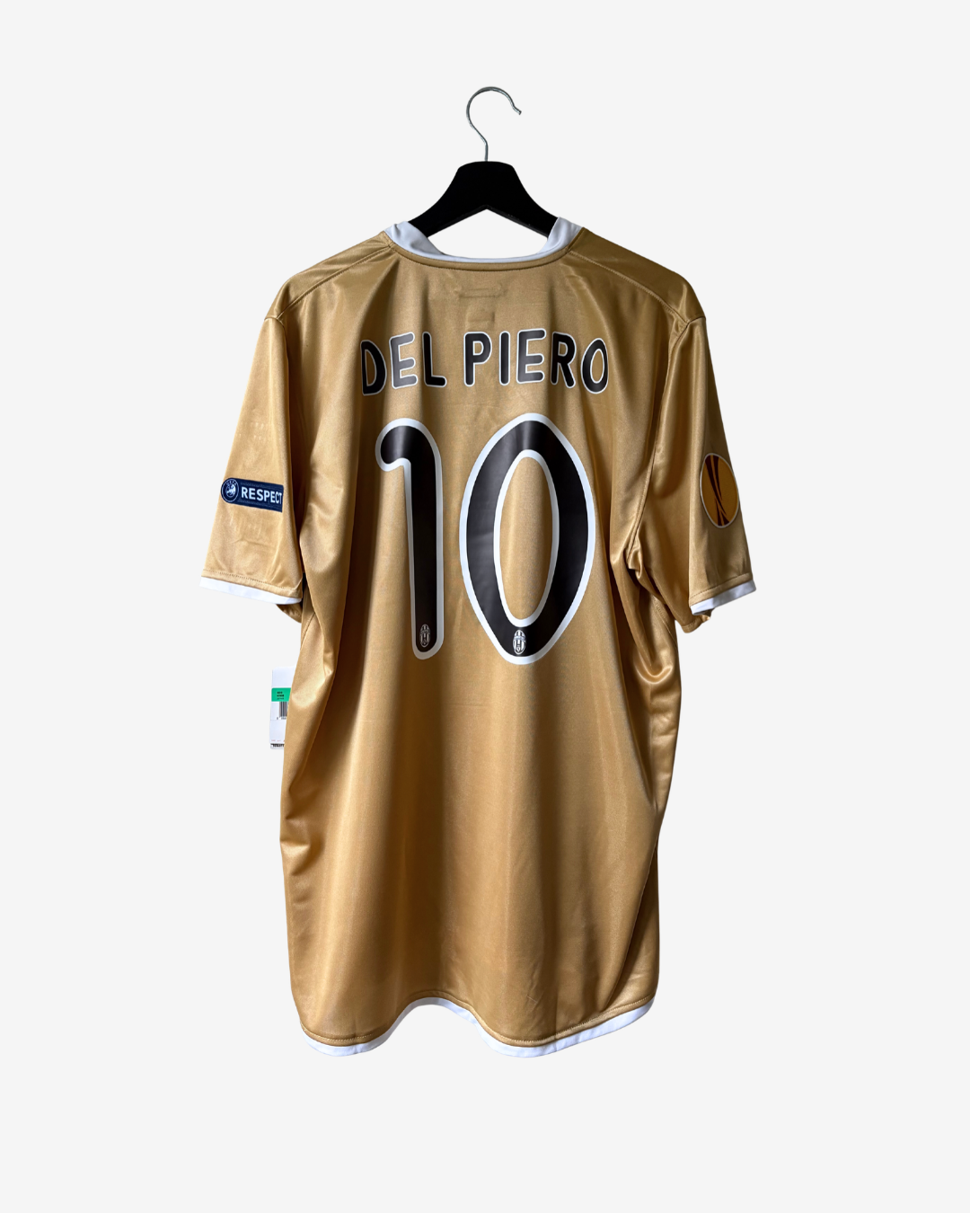 A gold soccer jersey with 'DEL PIERO 10' printed on the back, hanging on a black hanger against a light gray background.