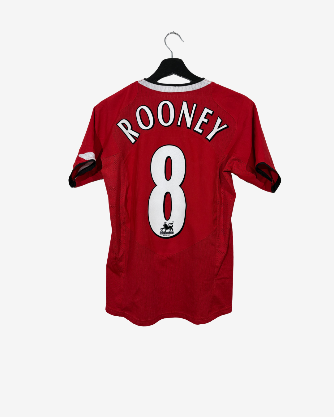 A red short-sleeve soccer jersey hanging on a black hanger against a light gray background. The back of the jersey features the name 'ROONEY' in white arched letters above a large white number '8'.