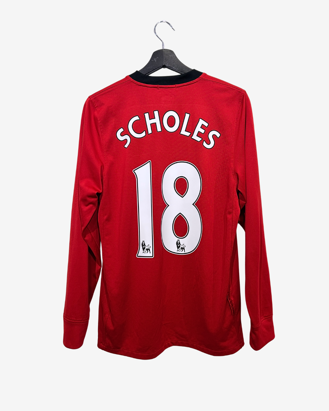 Red football jersey with 'Scholes' and number '18' on a hanger against a white background