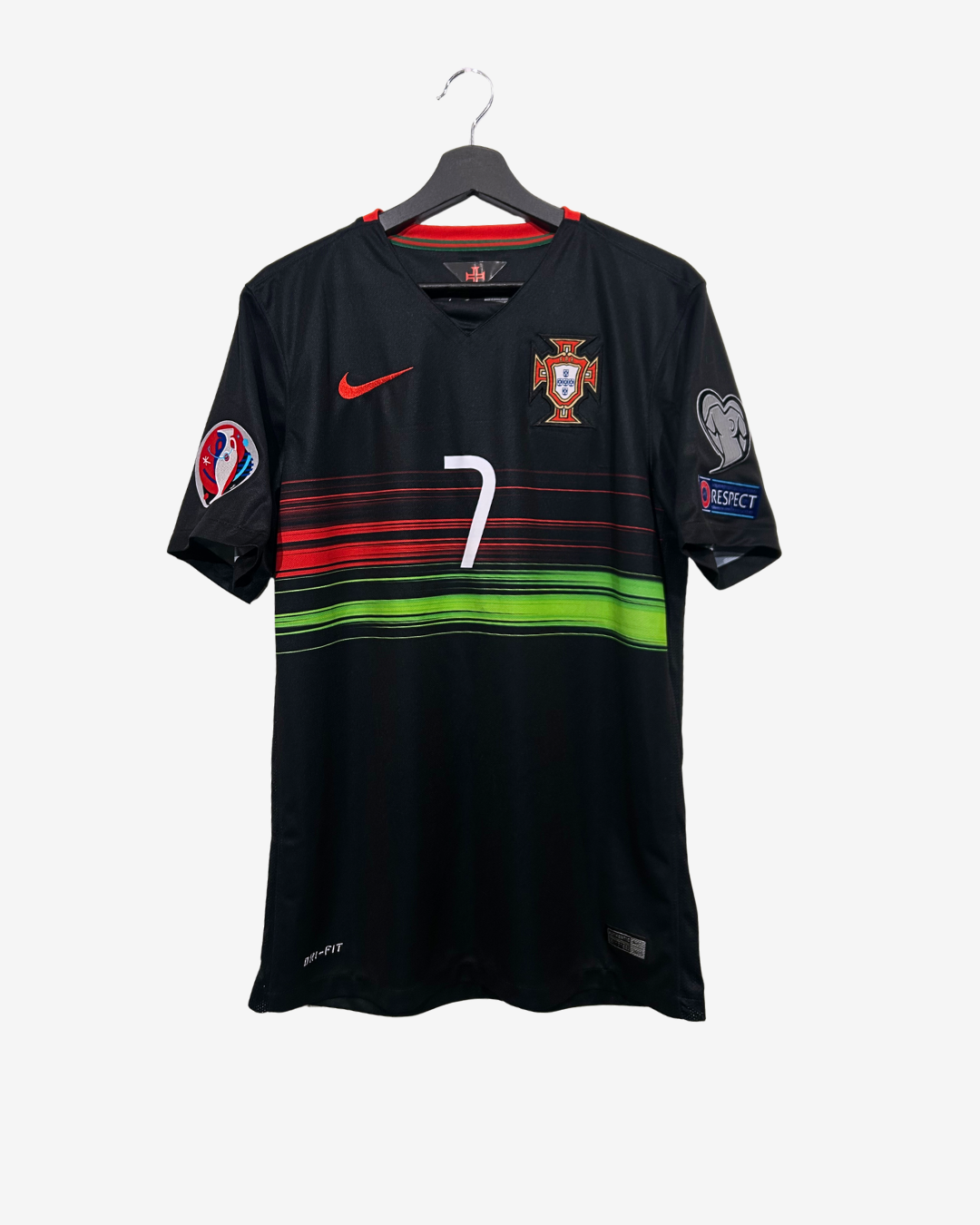 Black sports jersey with red and green accents on a hanger against a white background