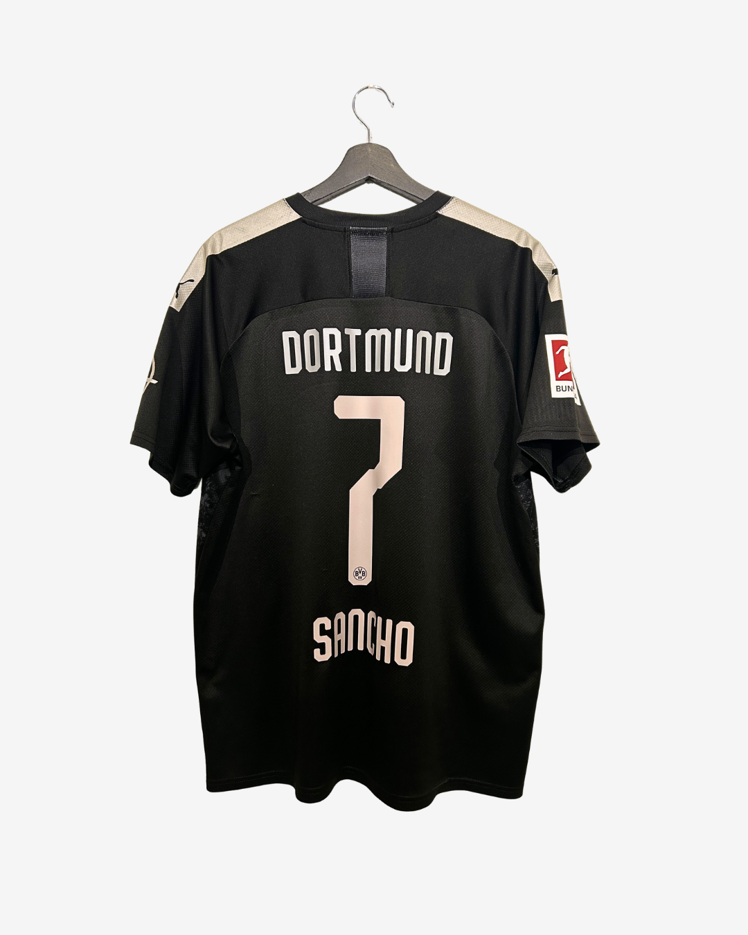 Black sports jersey with 'Dortmund' and number '7' on a hanger against a white background