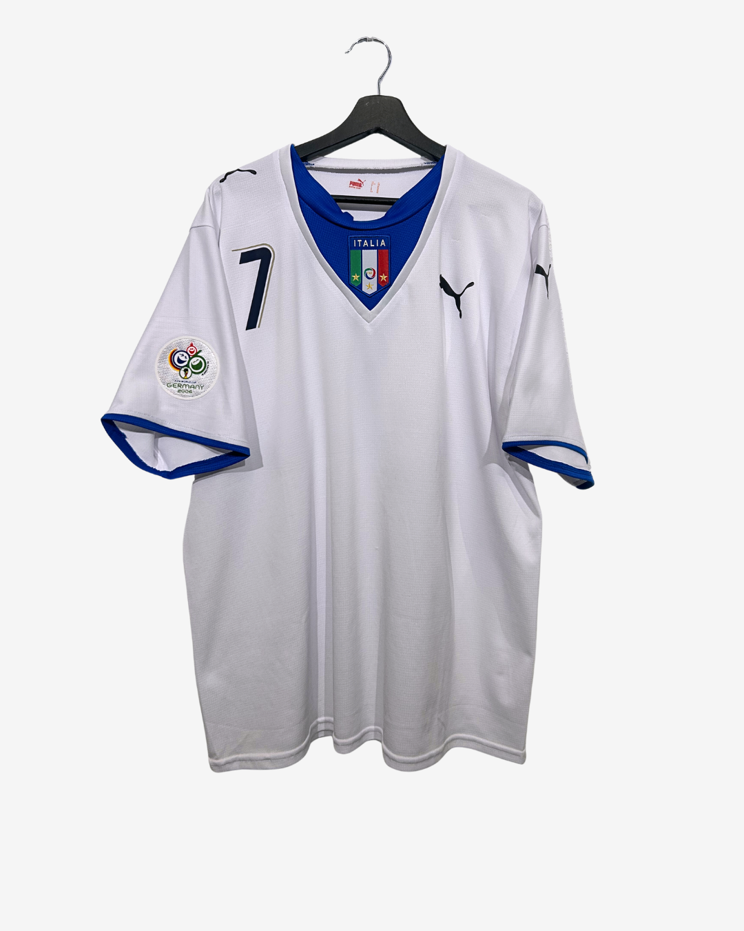 White soccer jersey with blue accents on a hanger against a white background