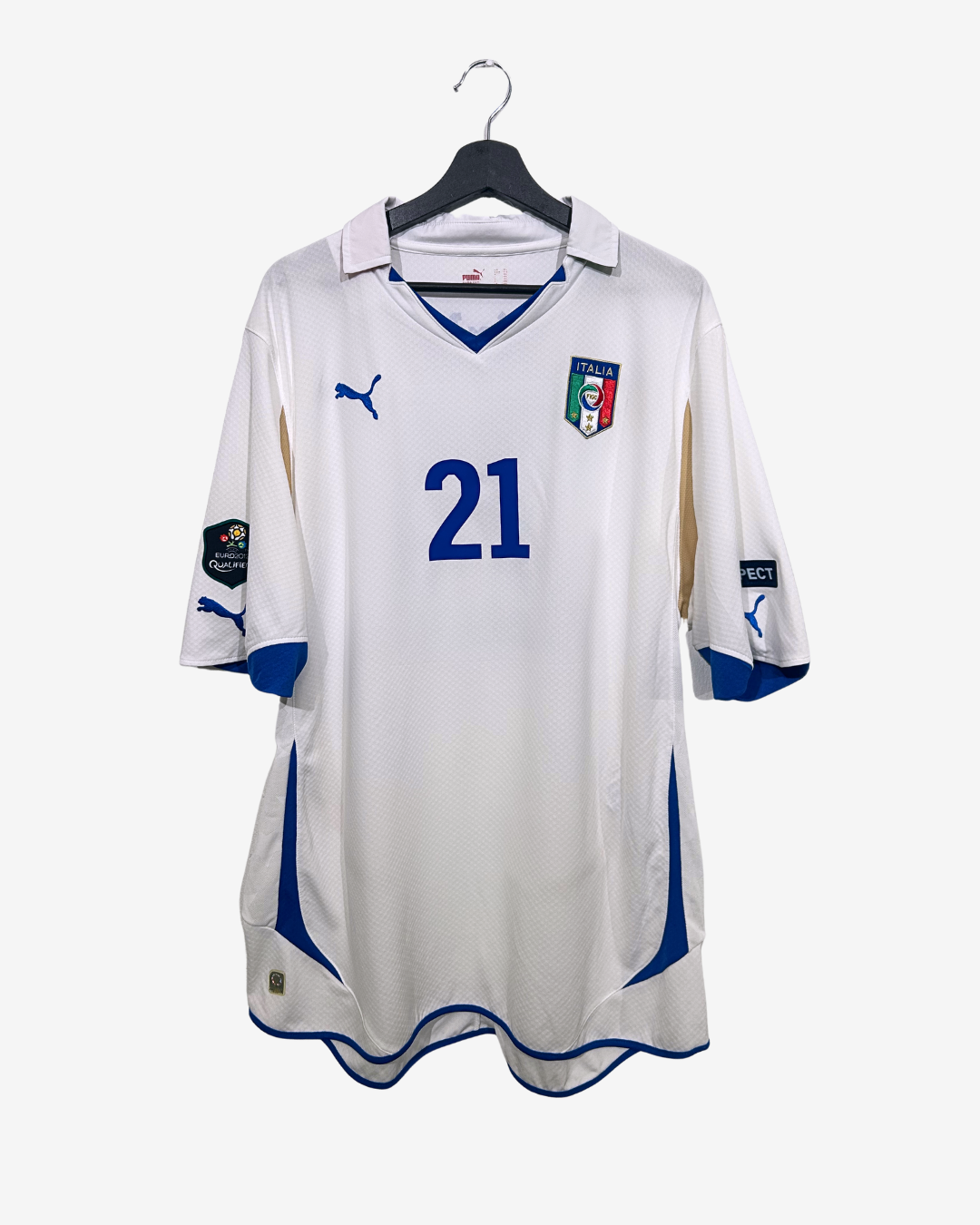 White soccer jersey with blue accents and number 21, hanging on a white background