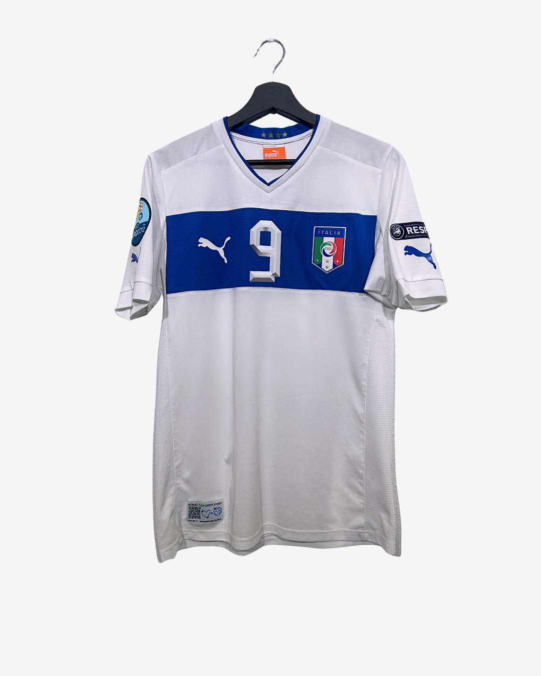 White sports jersey with blue stripe featuring number 9 and Italian flag, on a hanger against a white background.