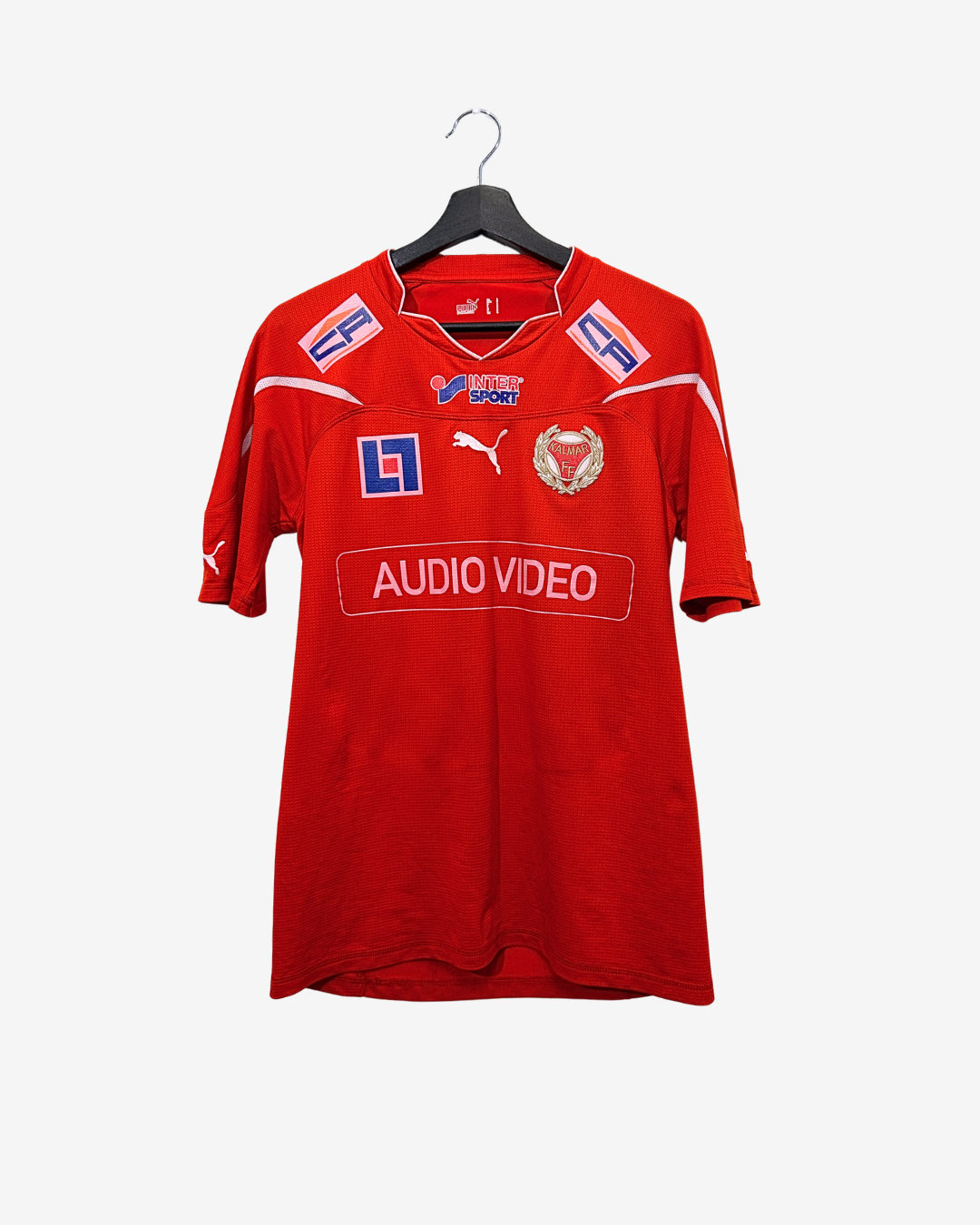 Red sports jersey with logos on a hanger against a white background