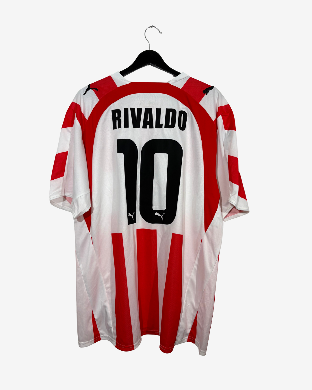 A red and white striped Puma soccer jersey with 'RIVALDO 10' printed on the back, hanging on a black hanger against a light gray background.