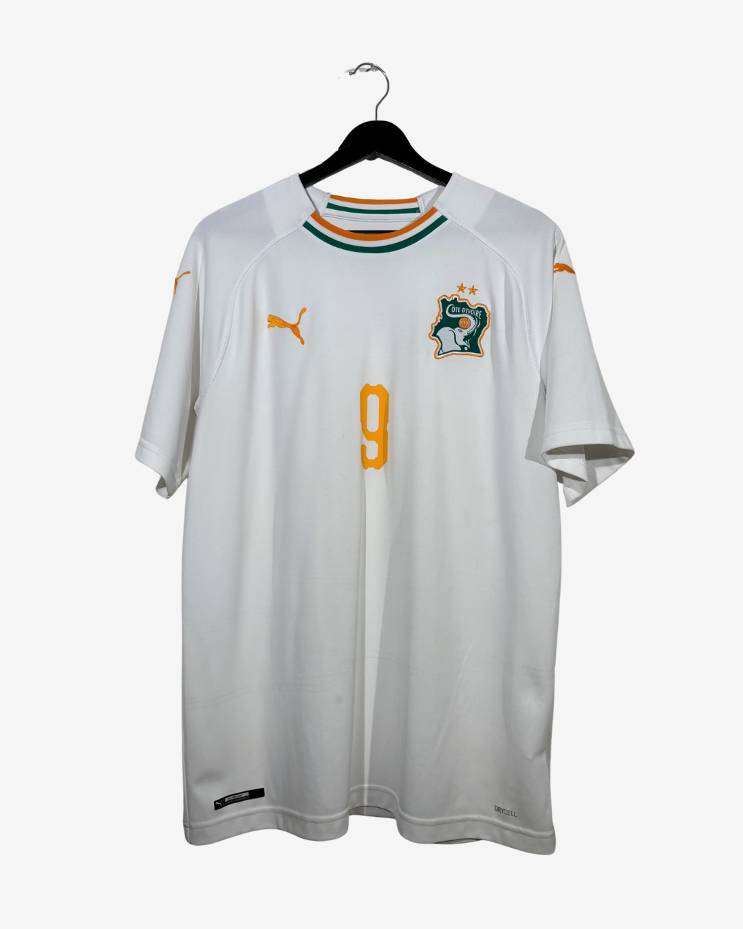 A white Puma Ivory Coast national football team jersey with the number 9, displayed on a black hanger against a light gray background.