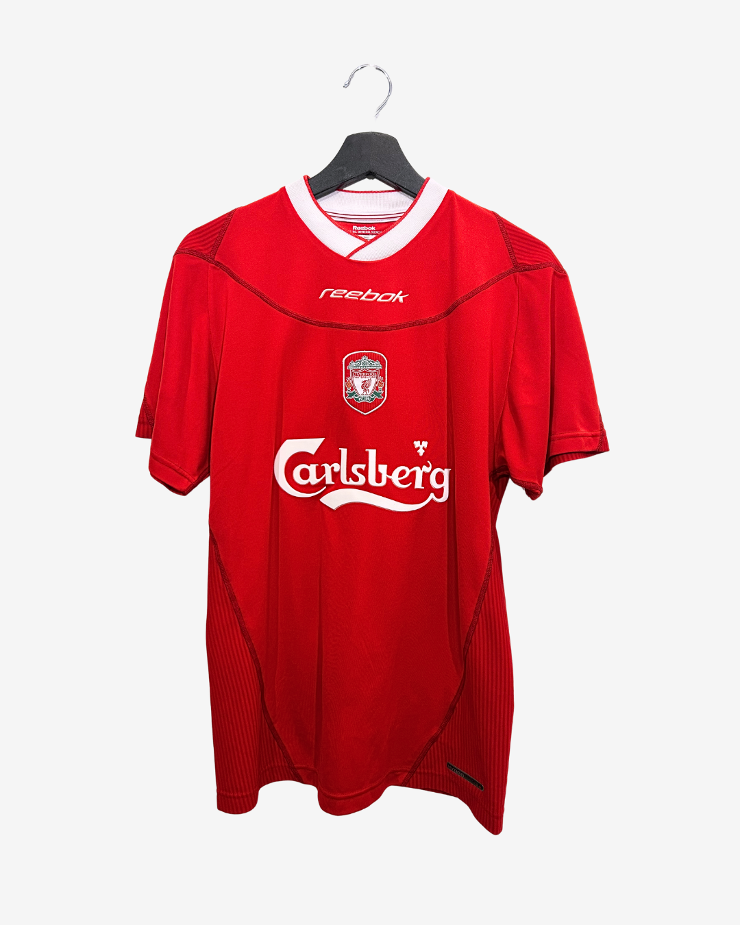 Red sports jersey with visible branding on a hanger against a white background