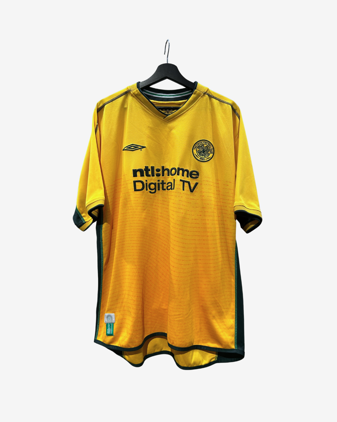 A yellow and green Scotland football jersey with 'ntshome Digital TV' sponsor logo, hanging on a black hanger against a light gray background.