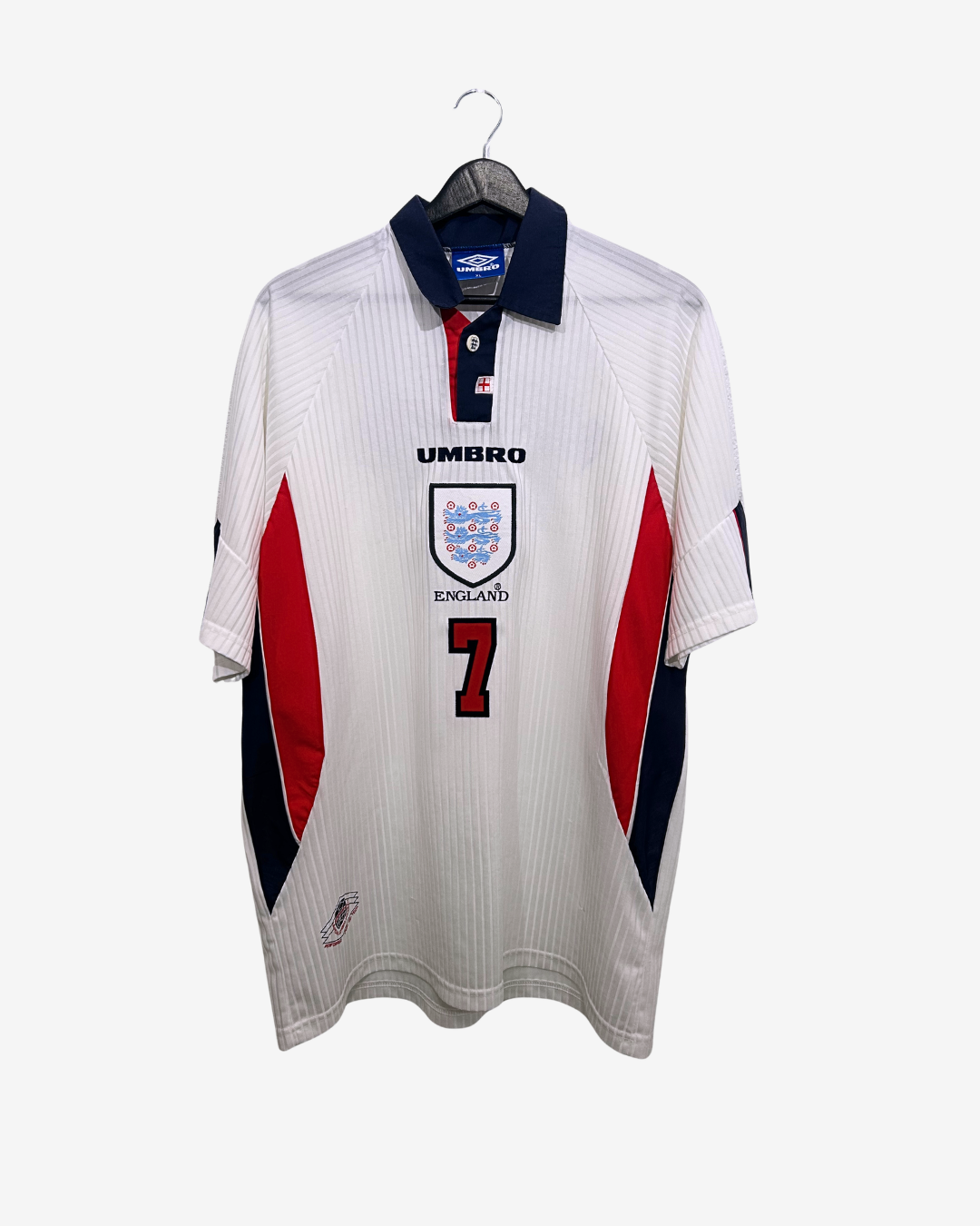 White sports jersey with red and blue accents on a hanger against a white background