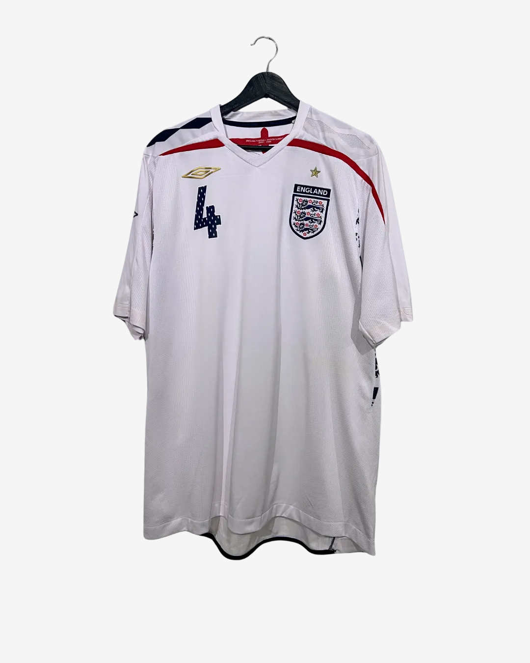 White sports jersey with red and blue accents on a hanger against a white background