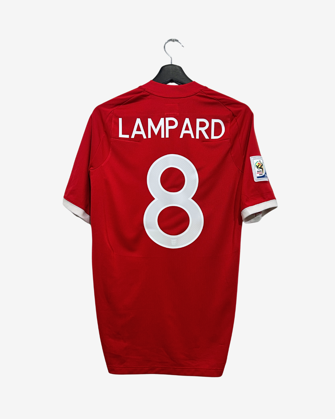 A red short-sleeve soccer jersey hanging on a black hanger against a light gray background. The back of the jersey features the name 'LAMPARD' in white block letters above a large white number '8'.