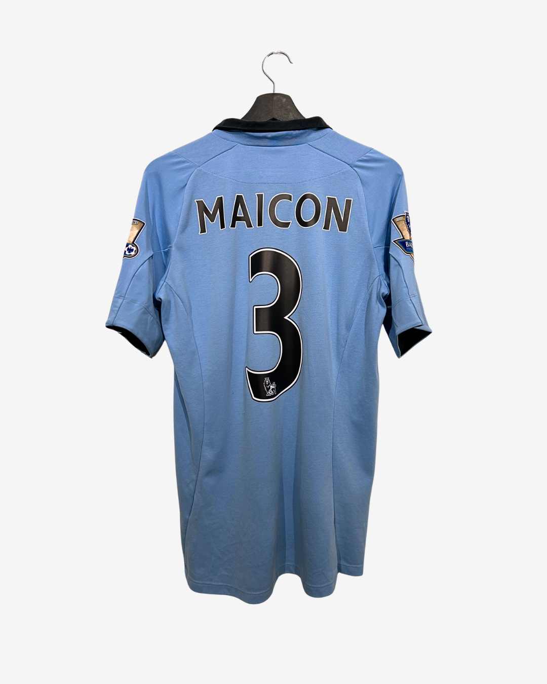 Blue sports jersey with 'MAICON' and number '3' on a hanger against a white background