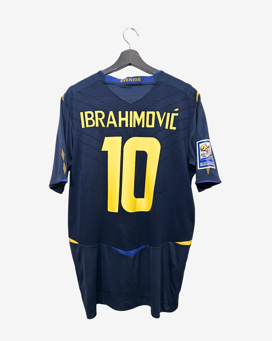 Navy blue sports jersey with yellow text and number on a hanger against a white background