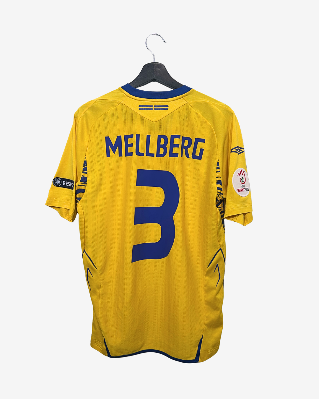 Yellow sports jersey with 'Mellberg' and number '3' on a hanger against a white background