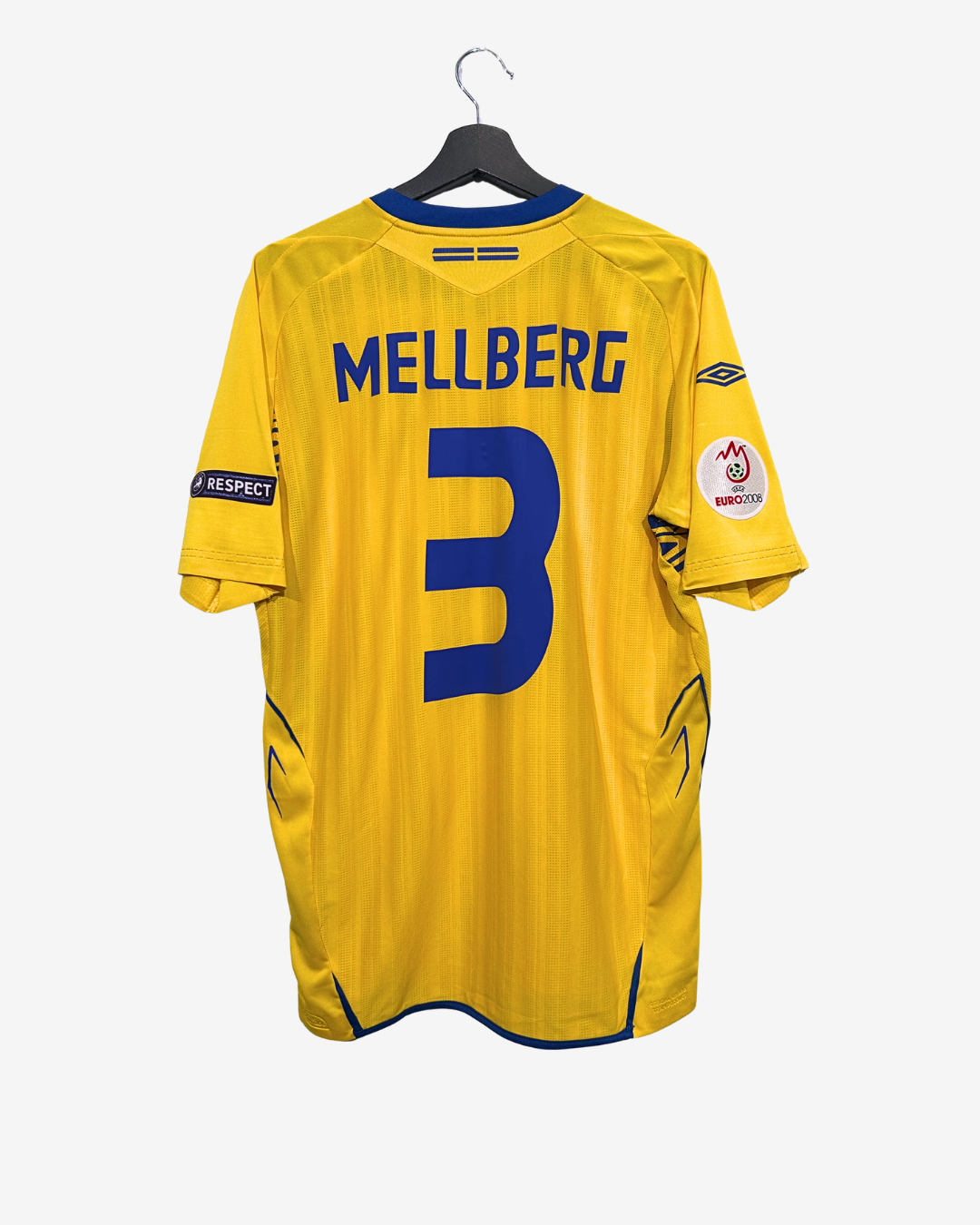 Yellow sports jersey with 'Mellberg' and number '3' on a hanger against a white background
