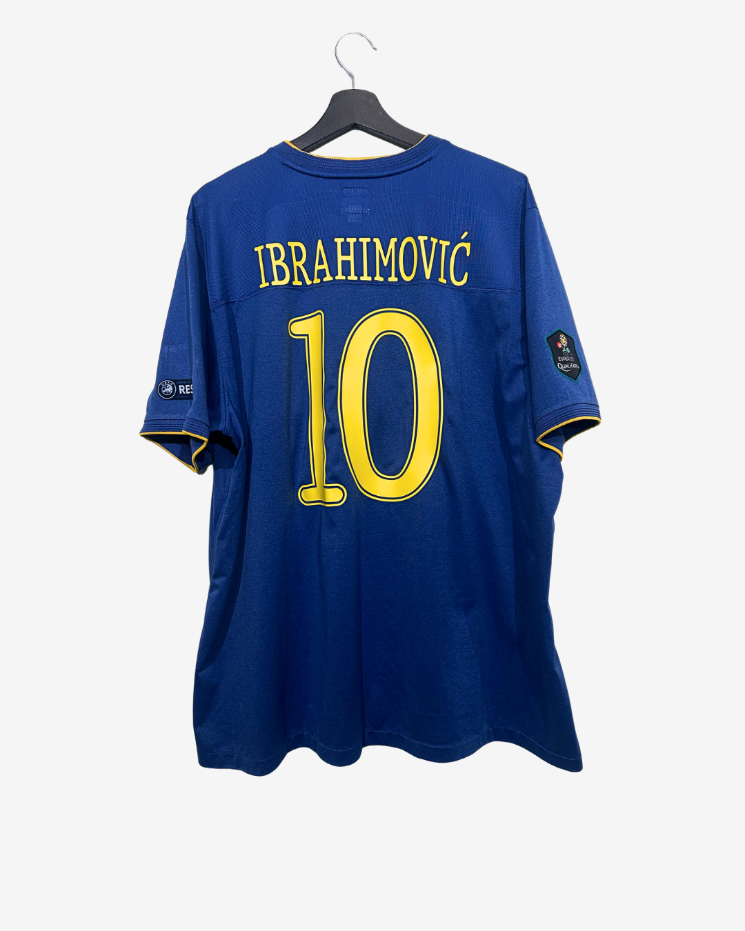 Blue sports jersey with yellow text and number on a hanger against a white background