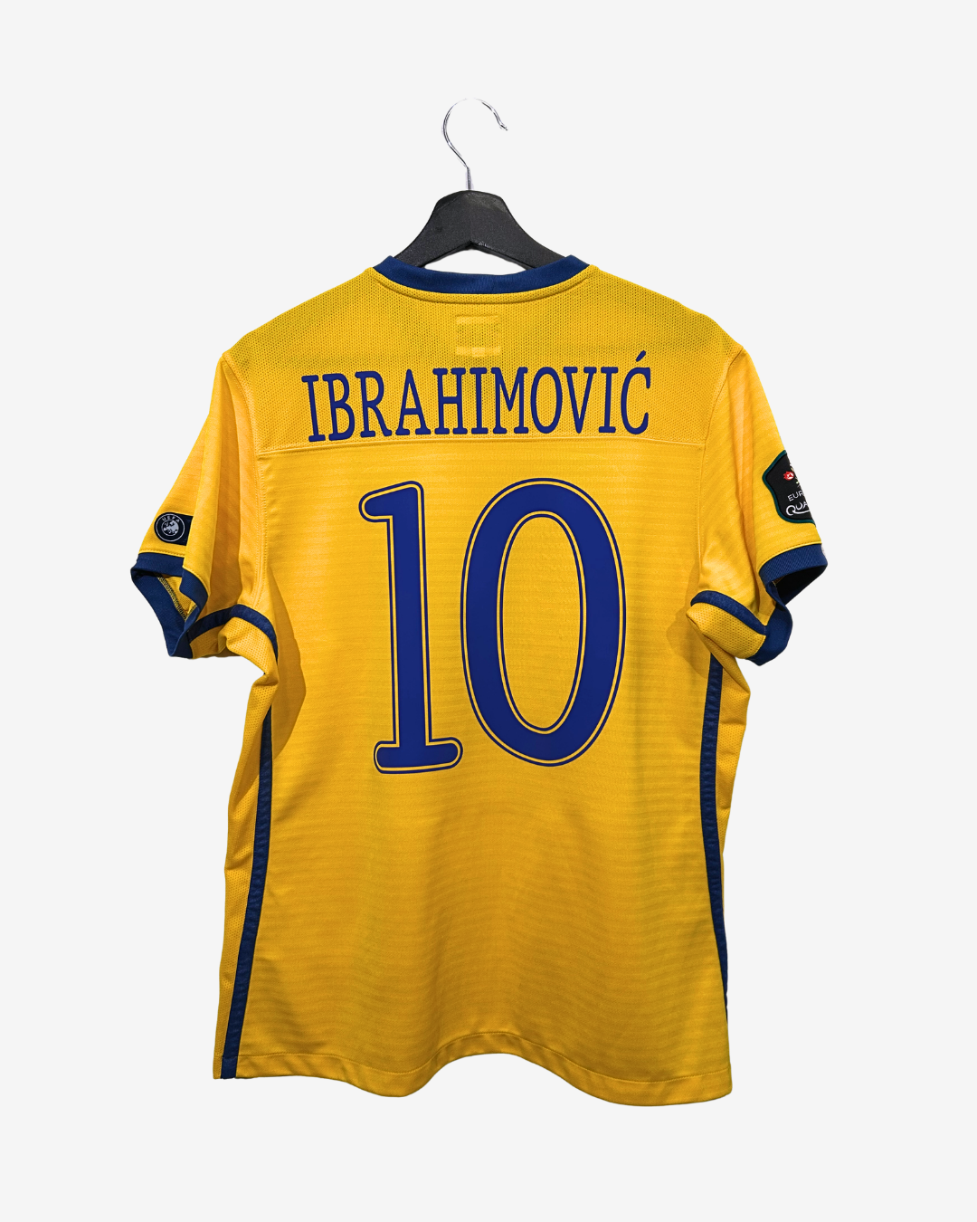 Yellow sports jersey with 'Ibrahimovic' and number '10' on a hanger against a white background