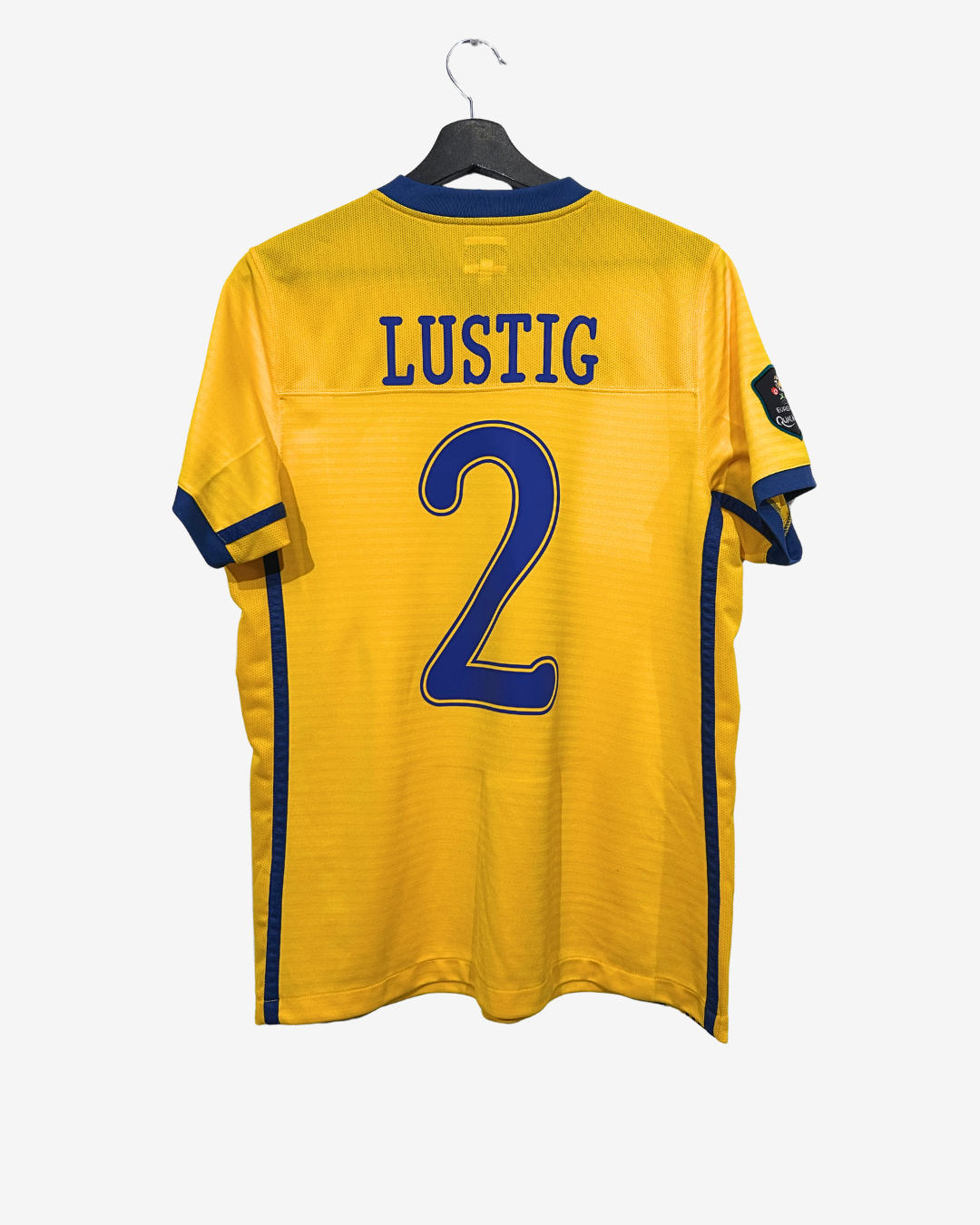 Yellow sports jersey with 'LUSTIG' and number '2' on a hanger against a white background