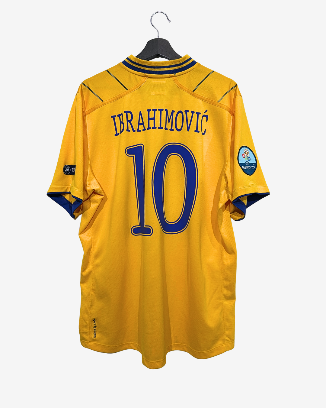Yellow sports jersey with 'Ibrahimovic' and number '10' on a hanger against a white background