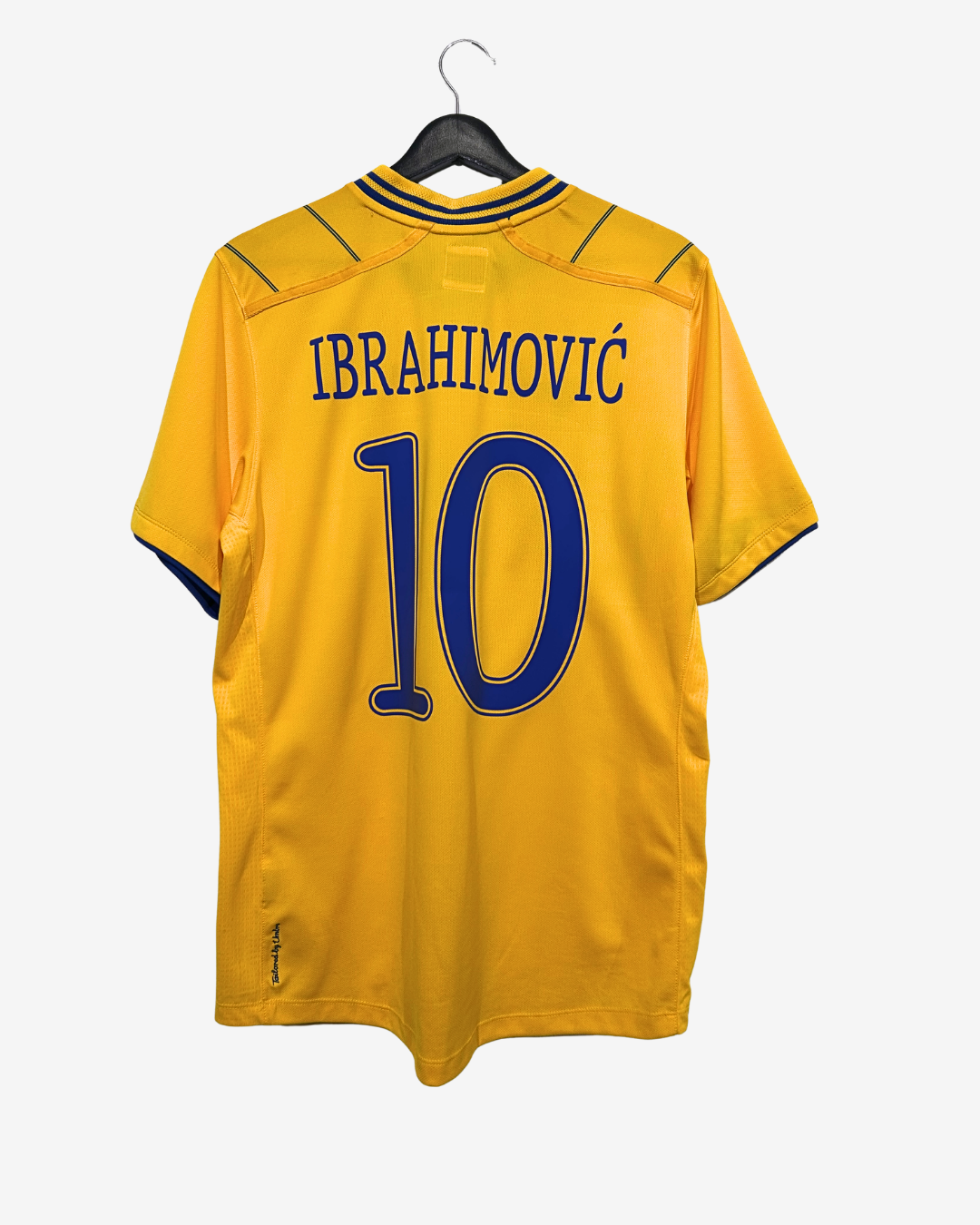 Yellow sports jersey with 'Ibrahimovic' and number '10' on a hanger against a white background