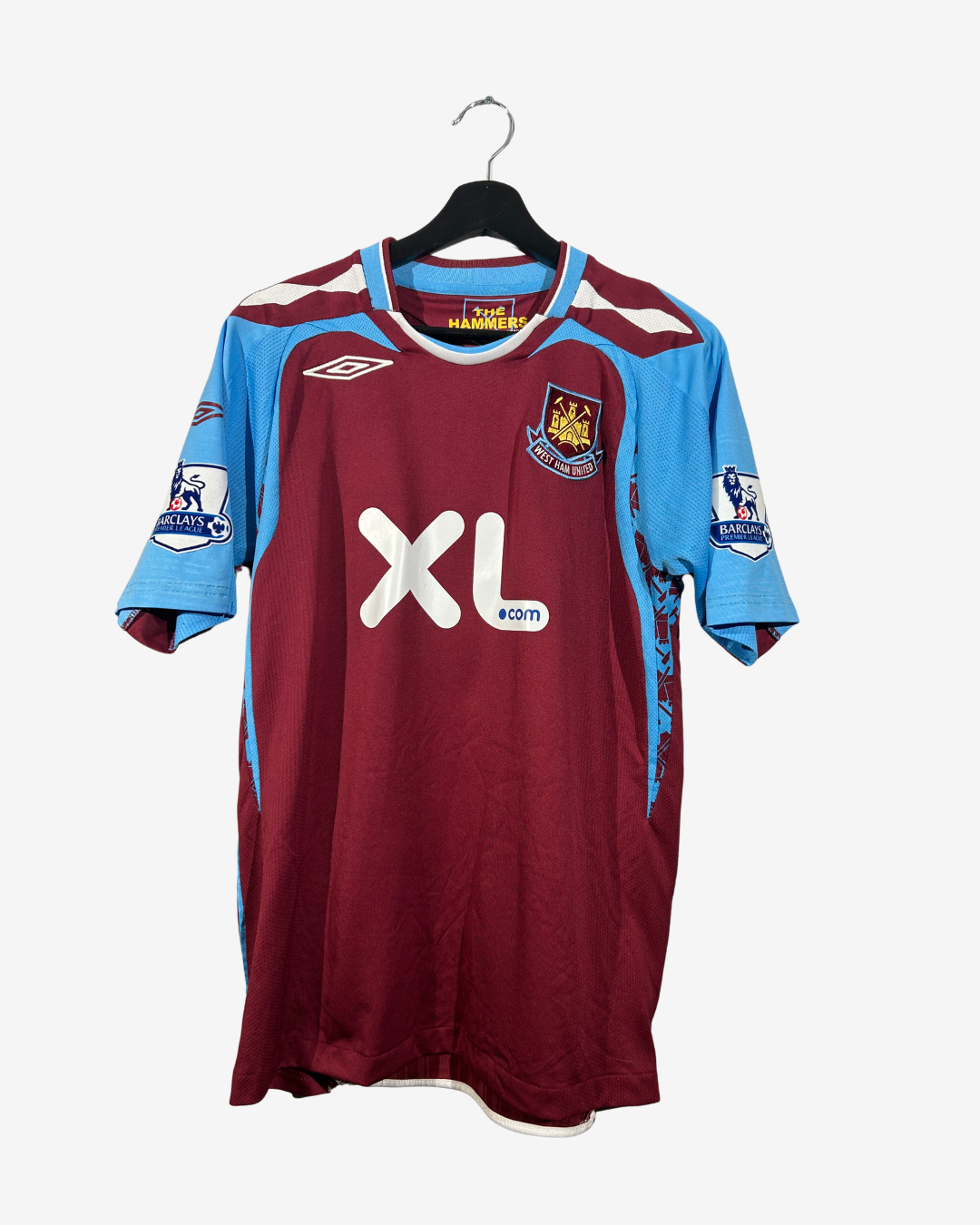 Maroon and blue sports jersey with XL size label on a hanger against a white background