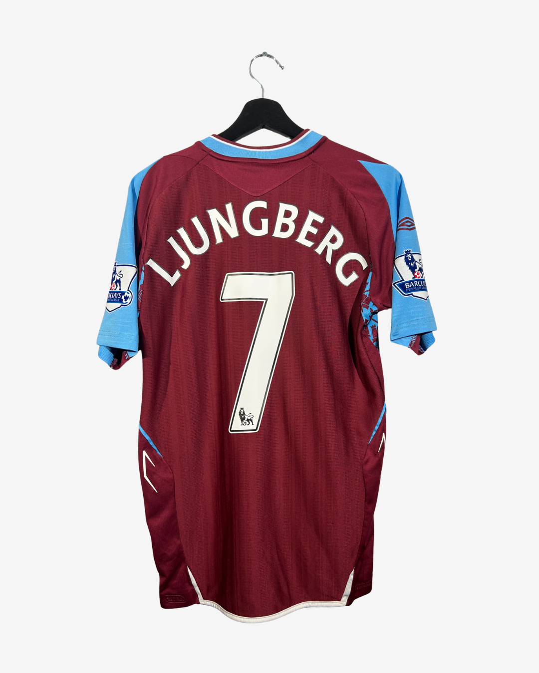 Maroon sports jersey with blue accents on a hanger against a white background