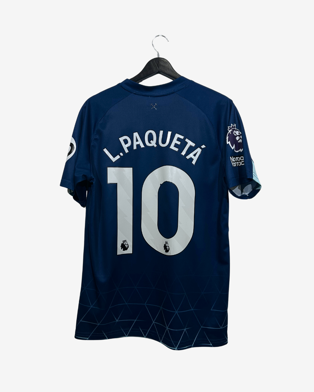 A navy blue soccer jersey with 'L. PAQUETÉ' and the number '10' in white on the back, hanging on a black hanger against a light gray background.
