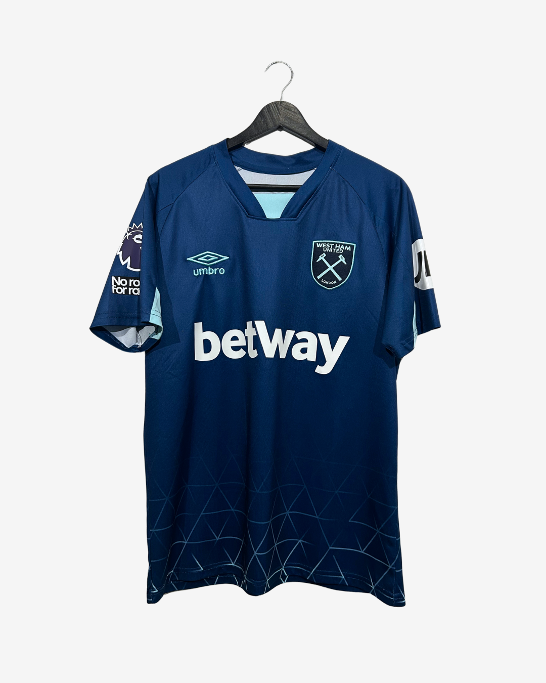 A dark blue West Ham United soccer jersey by Umbro, featuring the white Betway sponsor logo across the chest, hanging on a black hanger against a light gray background.